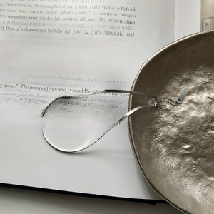 Elegant S925 sterling silver snake chain anklet resting on an open book and metal bowl