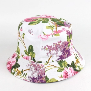 Dettaglio del motivo con rose rosa e tesa cucita sul cappello alla pescatora bianco