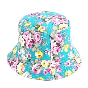 Dettaglio ravvicinato di un cappello a secchiello floreale in tela blu con rose rosa