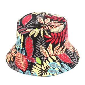 Dettaglio del cappello a secchiello stampato con foglie tropicali colorate su tessuto nero