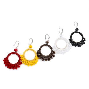 Detail of five pairs handmade woven beaded hoop earrings in red yellow brown white black