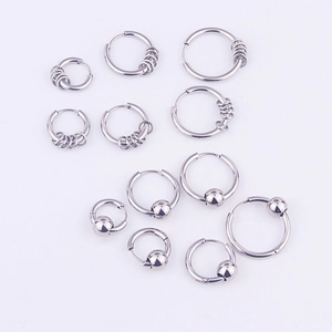 Close-up of stainless steel hoop earrings with ring and bead charms on grey background