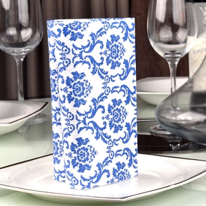 Blue floral printed paper napkins with Chinoiserie pattern on a white serving plate