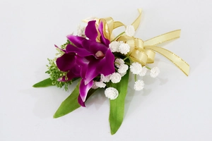 Detalle de ramillete de orquídea púrpura artificial con cinta dorada y flores blancas