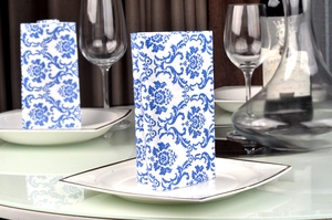 Close-up of Chinese style blue floral damask napkins folded on a white dining plate