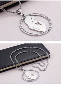 Macro detail of silver round pendant with rhinestone rim and praying female silhouette