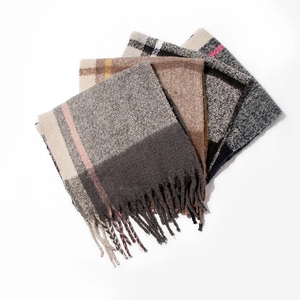 Macro shot of colorful checkered thick scarves with long tassels on a white background