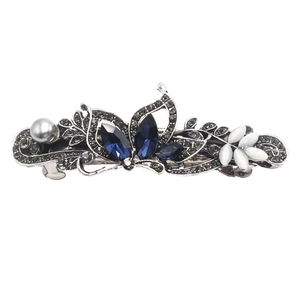 Detail of vintage hair clip with navy rhinestones, grey pearls and white leaves