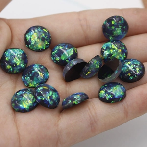 Macro detail of 12mm oval synthetic opal resin cabochons with blue-green foil glitter