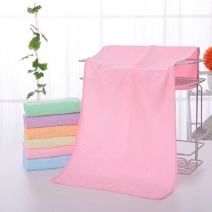 Close-up of pastel embossed bear microfiber towels displayed on a metal shelf