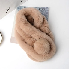 Close-up of soft khaki mink fur pompom pendant with a smooth, fluffy texture details