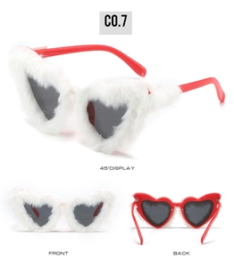 Detail view of heart-shaped sunglasses with white plush fur and red temples