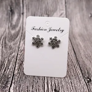 Detail view of snowflake stud earrings with crystals on a jewelry display card