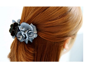 Close-up of blue fabric flower hair claw clip worn on a bun hairstyle with elegant detail