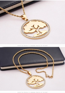 Detail of gold tree of life pendant with sparkling crystals and rope chain necklace