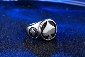 Macro shot of retro stainless steel ace of spades signet ring on textured blue background