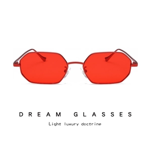 Detail view of red octagonal metal sunglasses with sleek geometric frames and tinted lenses