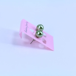 Olive green pearl stud earrings on pink jewelry card with silver butterfly backs