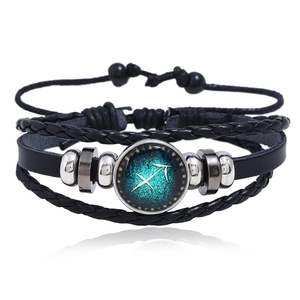 Detail of multi-layer leather bracelet with glowing Sagittarius zodiac glass cabochon