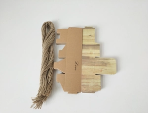 Draufsicht auf DIY-Geschenkbox aus Kraftpapier mit Love-Text, Herz-Ausschnitt und Hanfseil