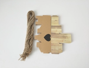 Flache Ansicht von DIY Kraftpapier-Süßigkeitenschachteln mit Herz-Ausschnitt und Jute-Garn