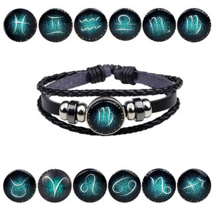 Macro shot of Virgo glowing glass charm on a black braided leather bracelet with 12 signs