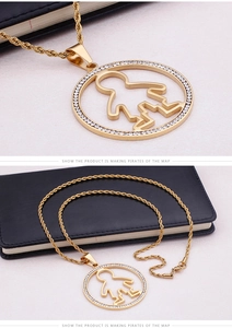 Detail of gold rope chain necklace with a circular boy silhouette pendant and crystals