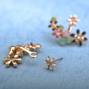 Detailed macro shot of floral ear jackets with colorful enamel petals and tiny rhinestones