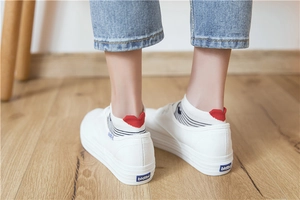 Close-up of black and white striped invisible socks with a red heart heel detail