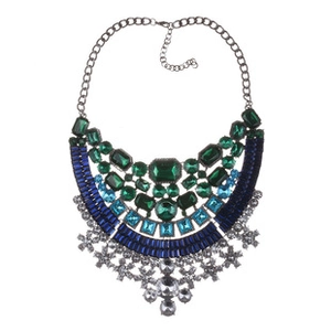 Detailed close-up of multi-layer statement necklace with emerald and sapphire gemstones