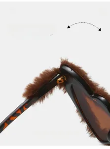 Detail view of durable metal hinges on plush heart sunglasses with tortoiseshell frames