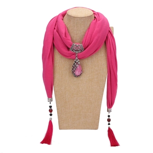 Pink ethnic scarf necklace featuring a peacock pendant and tassels on a mannequin