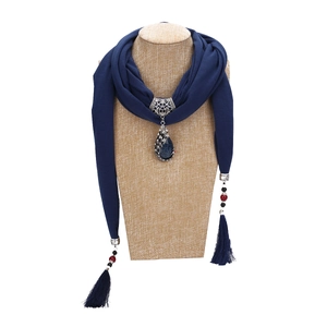 Ethnic peacock pendant scarf necklace with blue ceramic beads and tassels on a mannequin