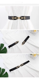 Detail of thin elastic black waist belt with golden metal buckle on a white dress