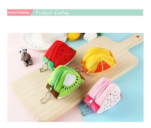 Set of four plush fruit coin purses including watermelon and orange on a wooden tray