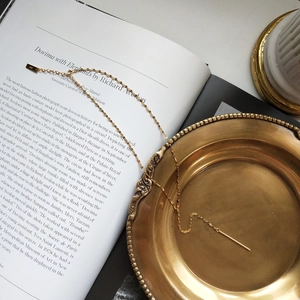 Detailed close-up of S925 sterling silver stamp on a minimalist gold bar pendant necklace