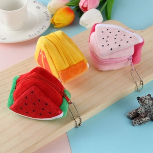 Cute fruit plush coin purses in watermelon and orange shapes on a wooden tray
