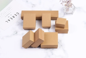 Detail view of various sizes of kraft paper jewelry boxes on a marble surface