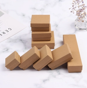 Various sizes of vintage kraft paper jewelry boxes on marble background with dry flowers