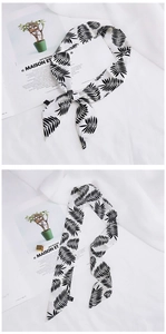 Detail of a thin silk scarf featuring black and white leaf patterns on a soft fabric