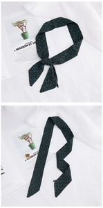 Close-up of dark green paisley silk twilly scarf with satin texture for handbags