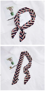 Close-up of red and blue geometric pattern silk scarf tied on handle with detail stitching