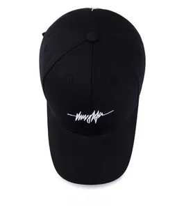 Vue de dessus d'une casquette de baseball noire avec logo brodé blanc en cursive