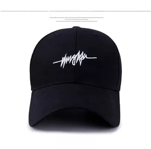 Détail de face d'une casquette de baseball noire avec broderie cursive blanche sur l'avant