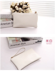 Detail view of cream crocodile-embossed PU leather clutch bag with wristlet and gold zipper