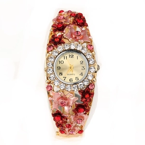 Detail of floral bangle watch featuring crystal bezel and red enamel flower accents