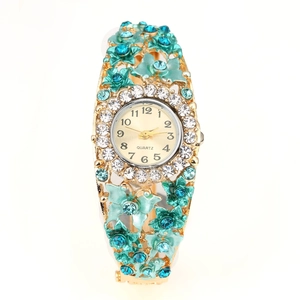 Detailed macro of gold flower bangle watch with blue crystals and rhinestone bezel
