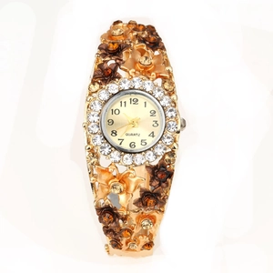Close-up of gold flower bangle watch with crystal accents and floral hollow band