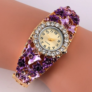 Close-up of golden floral bangle watch with purple gradient petals and crystals