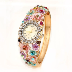 Macro side view of hollow floral bangle watch with multicolored gemstones and gold finish